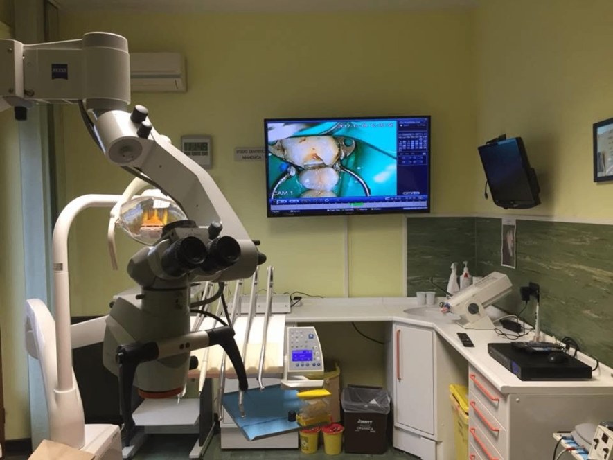 Sala operatoria dello studio dentistico con microscopio operatorio e monitor